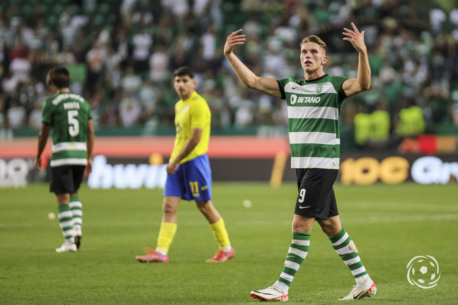  Viktor Gyokeres is celebrating a goal with his hands in the air while Ruben Amorim is in the background.